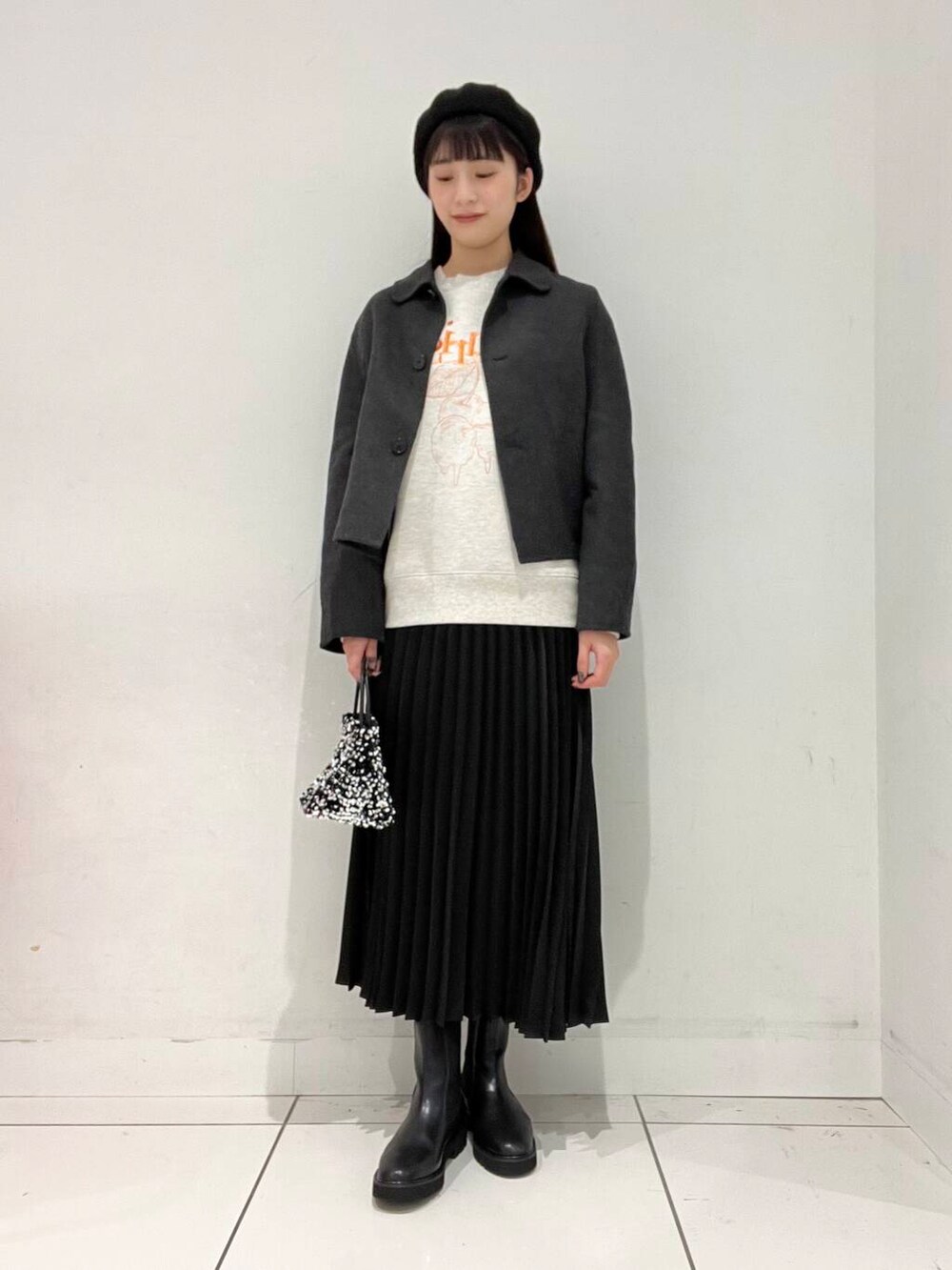 シルバー系のショルダーバッグ、グレー系のブルゾン、ブラック系のブーツを着用したレディースの秋コーディネートの2枚目の写真