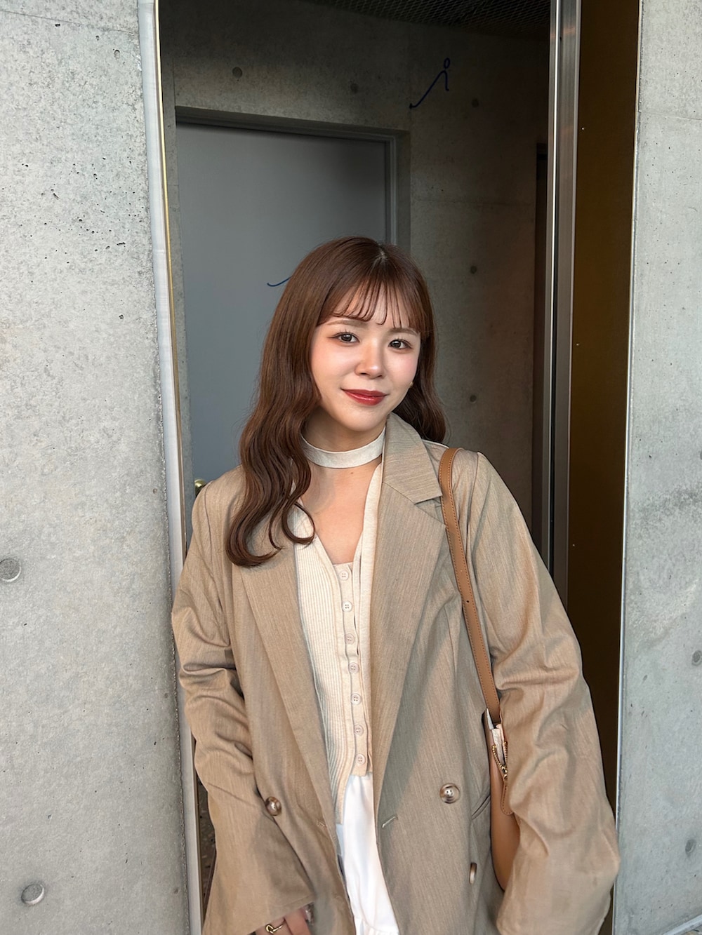 ベージュ系のスニーカー、ベージュ系のニット/セーター、ホワイト系のスカートを着用したレディースの春コーディネートの2枚目の写真