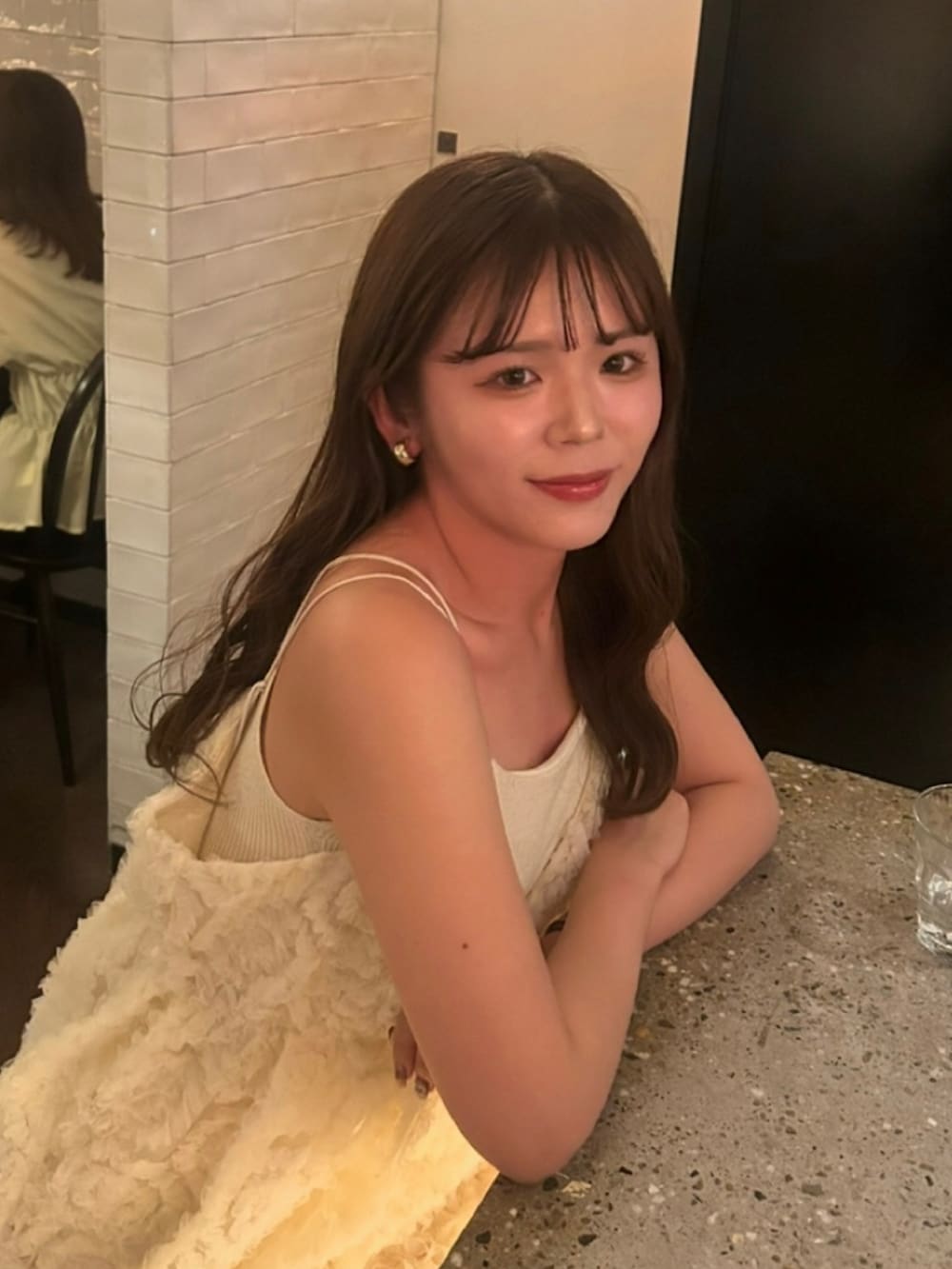 ベージュ系のトップス、ホワイト系のドレス、ベージュ系のスニーカーを着用したレディースの夏コーディネートの2枚目の写真