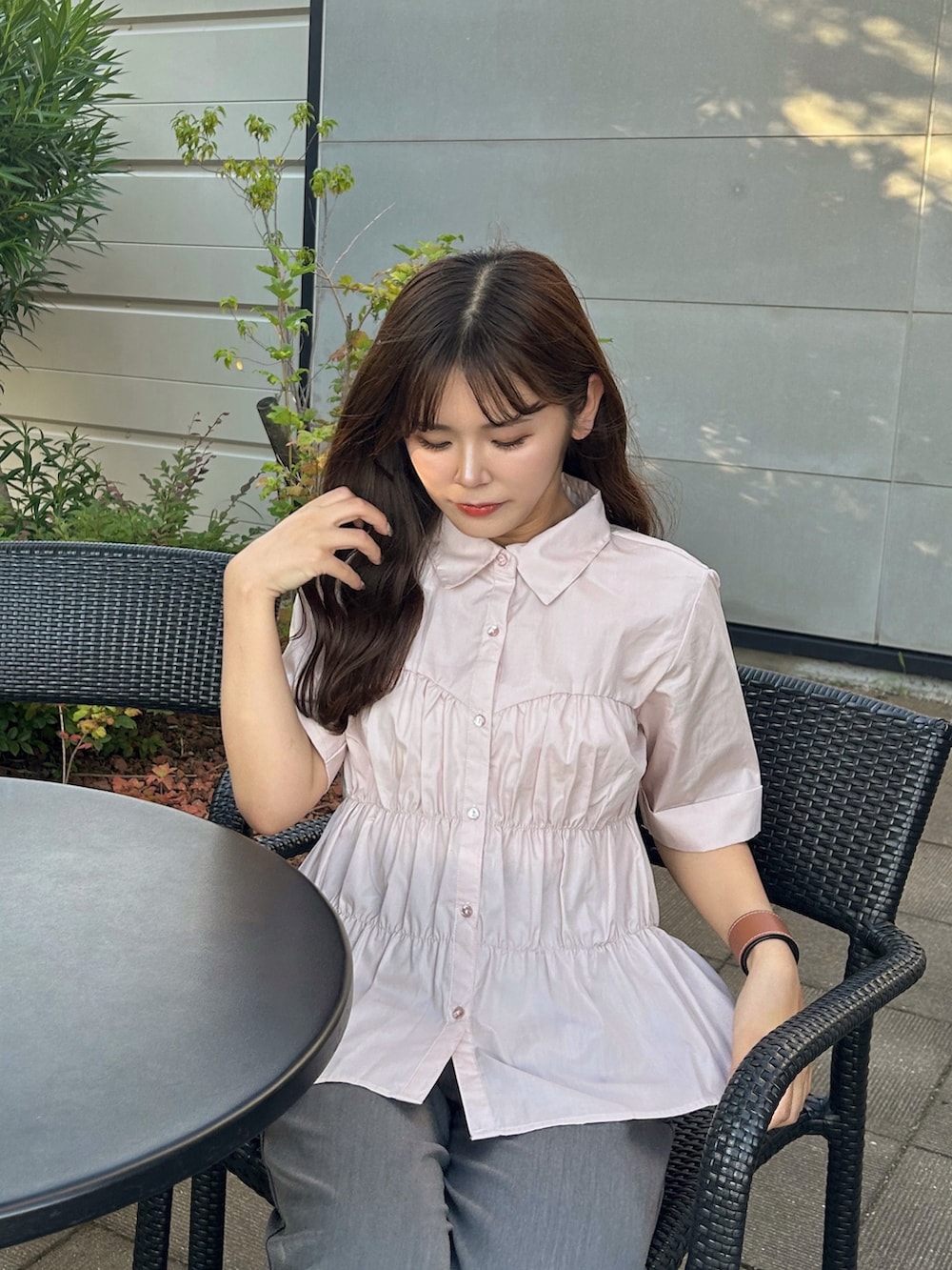 ピンク系のシャツ/ブラウス、グレー系のパンツ、ベージュ系のサンダルを着用したレディースの夏コーディネートの2枚目の写真