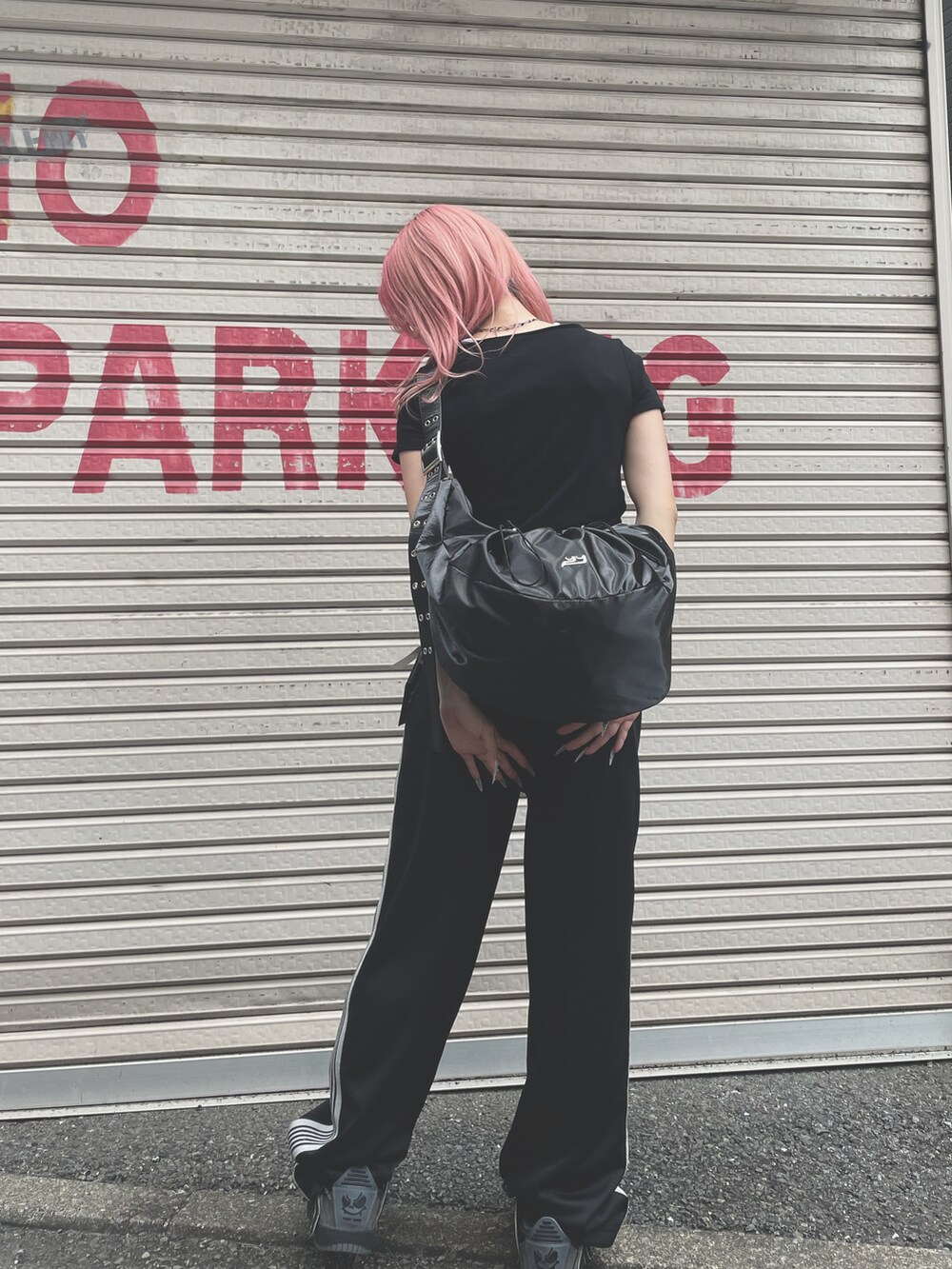 ブラック系のパンツ、グレー系のスニーカー、ブラック系のショルダーバッグを着用したレディースの夏コーディネートの2枚目の写真