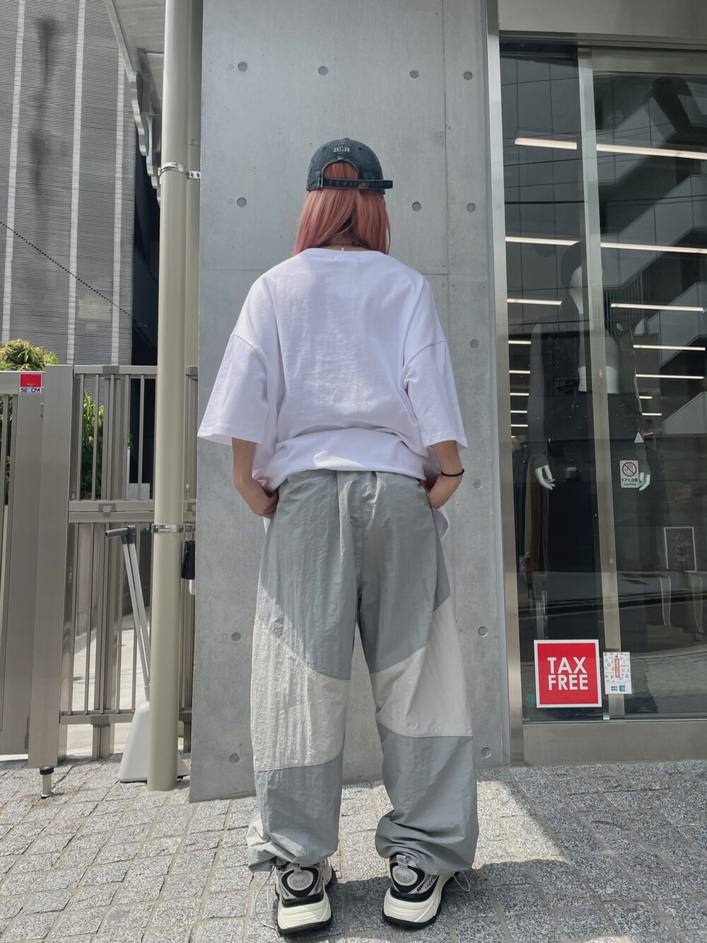 ホワイト系のTシャツ/カットソー、ホワイト系のパンツ、シルバー系のスニーカーを着用したレディースの夏コーディネートの2枚目の写真