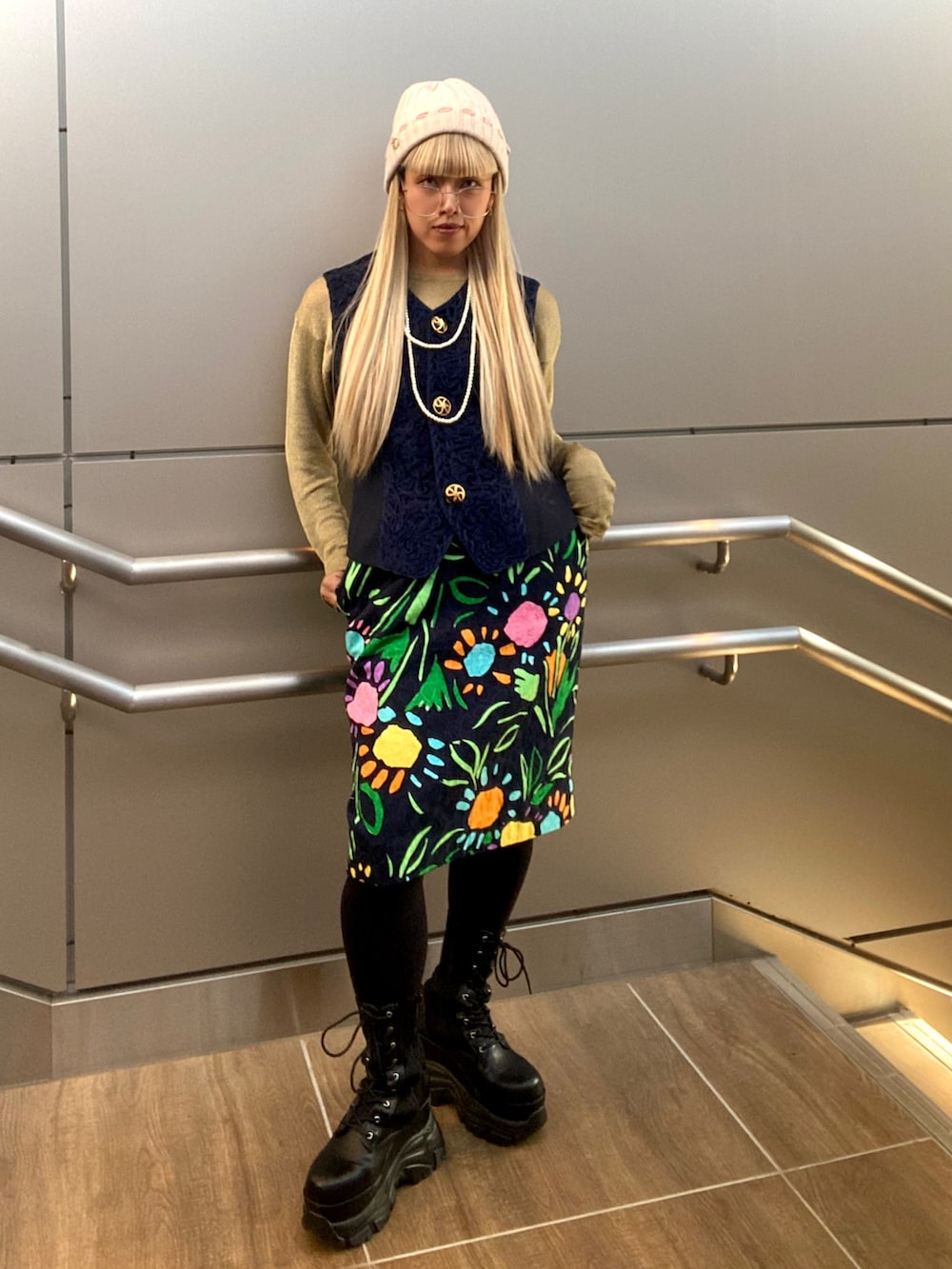 ゴールド系のトップス、ブルー系のベスト、その他のスカートを着用したレディースの秋コーディネートの5枚目の写真