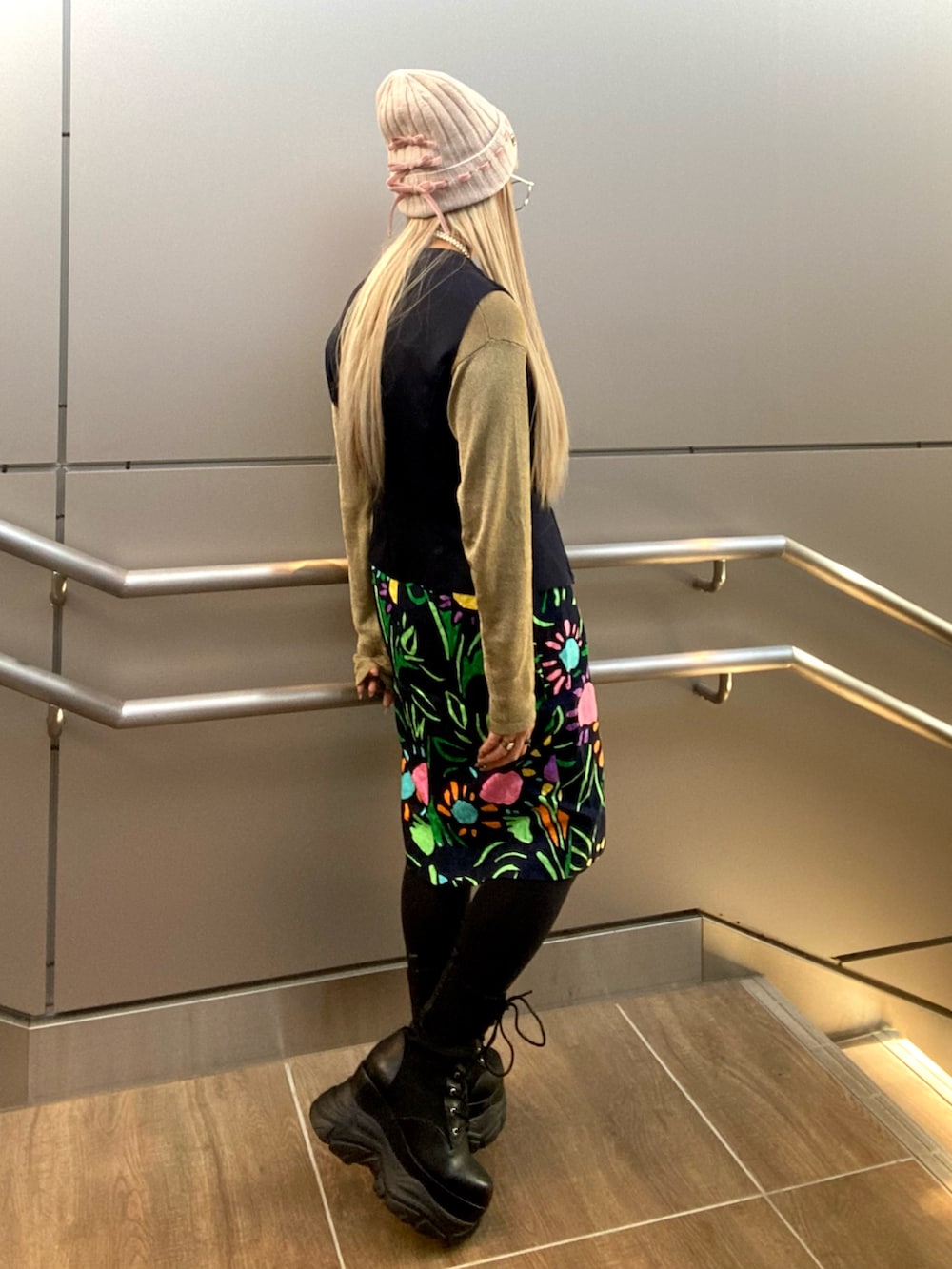 ゴールド系のトップス、ブルー系のベスト、その他のスカートを着用したレディースの秋コーディネートの3枚目の写真