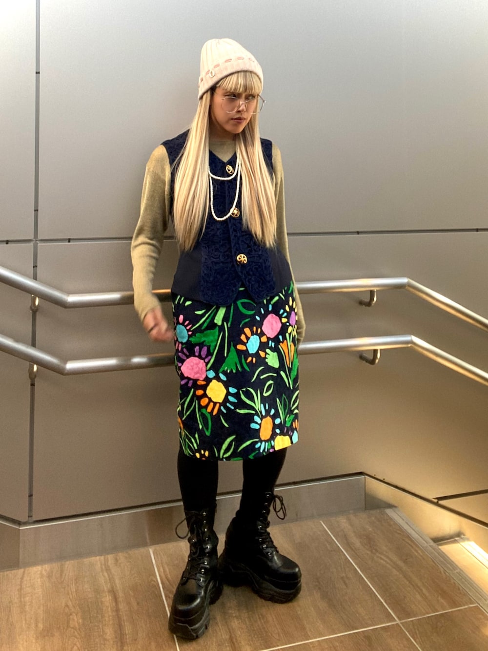 ゴールド系のトップス、ブルー系のベスト、その他のスカートを着用したレディースの秋コーディネートの2枚目の写真