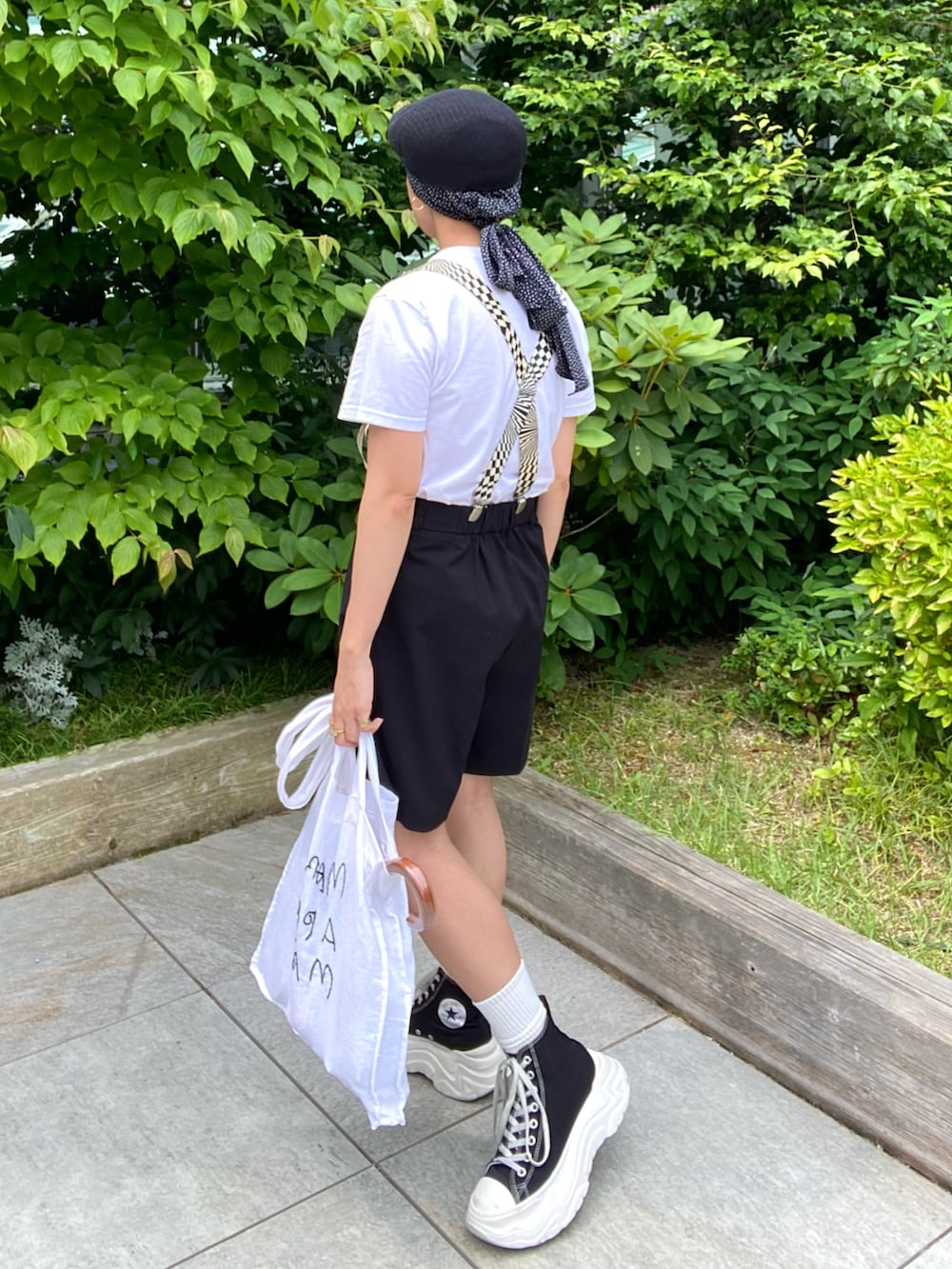 ブラック系のパンツ、ホワイト系のトートバッグ、ホワイト系のTシャツ/カットソーを着用したレディースの夏コーディネートの4枚目の写真