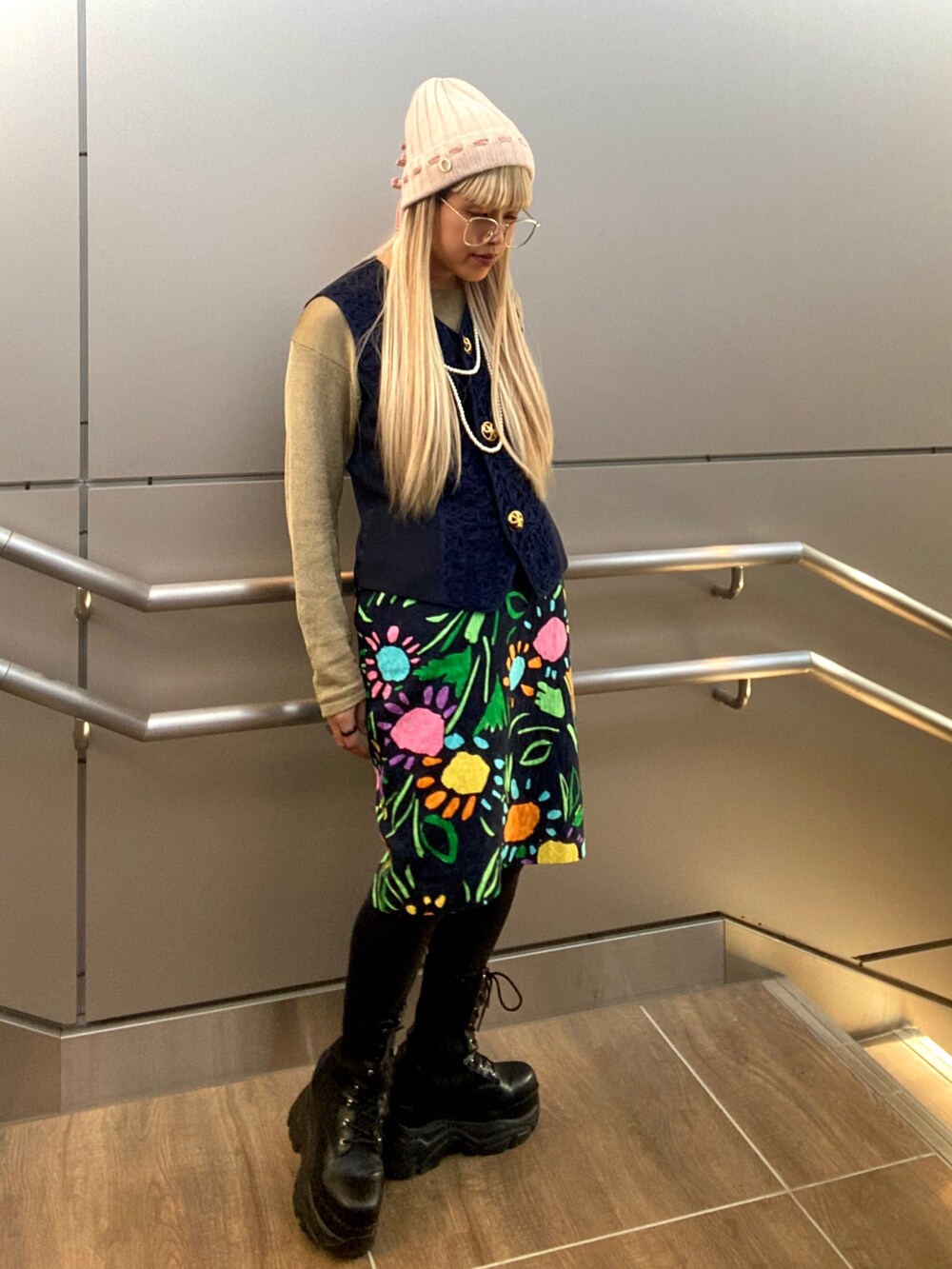 ゴールド系のトップス、ブルー系のベスト、その他のスカートを着用したレディースの秋コーディネートの4枚目の写真