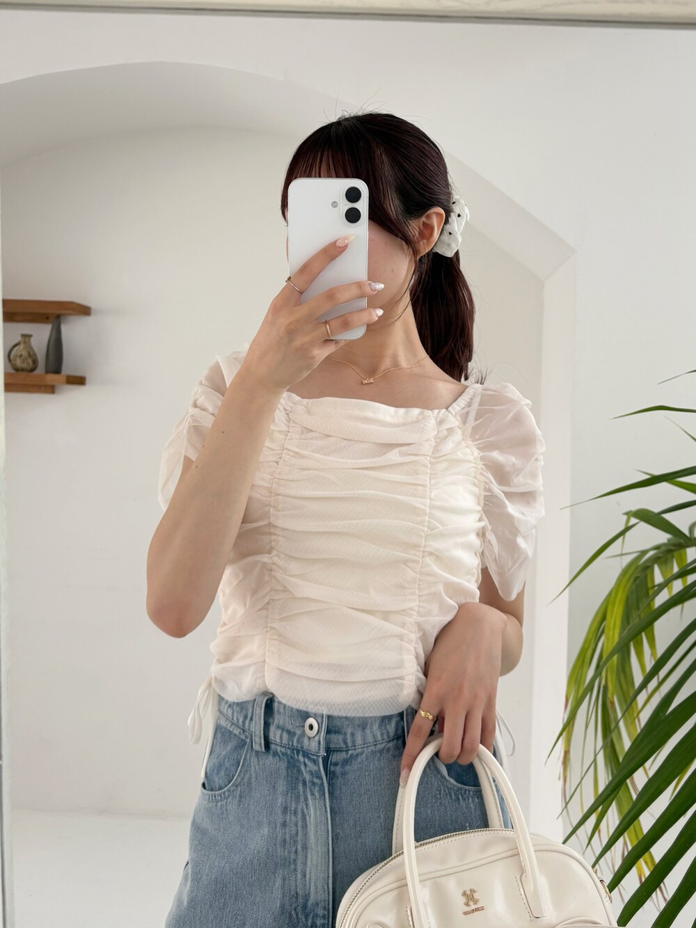 ホワイト系のシャツ/ブラウス、ブルー系のデニムパンツ、ホワイト系のショルダーバッグを着用したレディースの春コーディネートの5枚目の写真