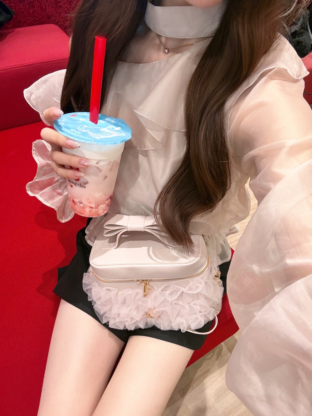 ピンク系のシャツ/ブラウス、ピンク系のショルダーバッグ、ブラック系のその他パンツを着用したレディースの冬コーディネートの2枚目の写真