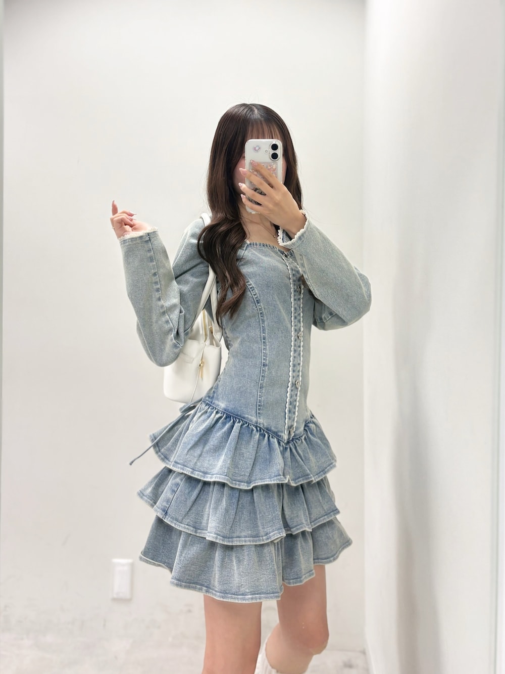 ブルー系のワンピース、ホワイト系のハンドバッグ、ホワイト系のスニーカーを着用したレディースの冬コーディネートの2枚目の写真