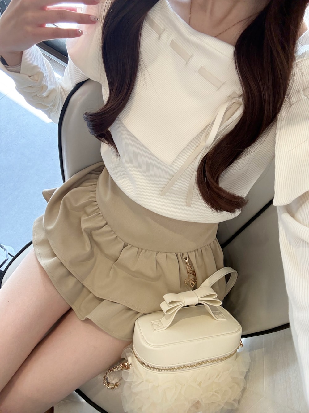 ホワイト系のTシャツ/カットソー、ベージュ系のスカート、ホワイト系のショルダーバッグを着用したレディースの春コーディネートの3枚目の写真