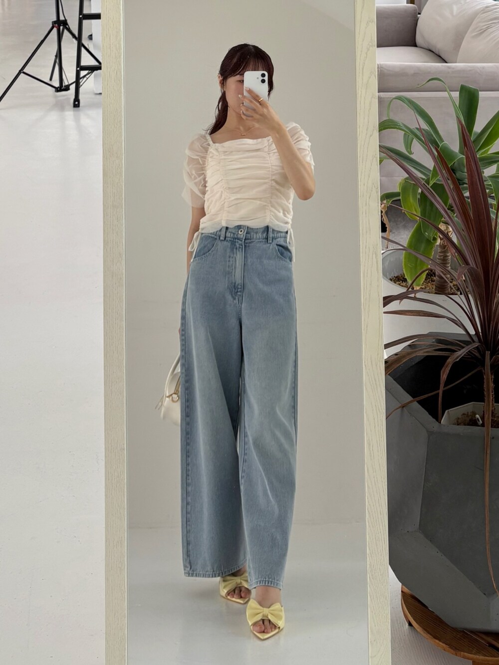 ホワイト系のシャツ/ブラウス、ブルー系のデニムパンツ、ホワイト系のショルダーバッグを着用したレディースの春コーディネートの3枚目の写真