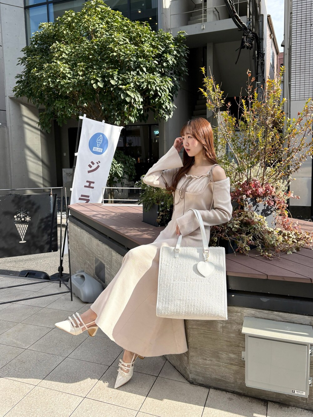 ホワイト系のワンピース、ホワイト系のトートバッグ、ホワイト系のパンプスを着用したレディースの冬コーディネートの4枚目の写真