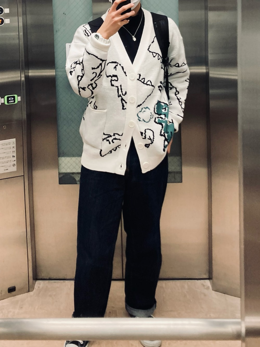 ブラック系のTシャツ/カットソー、ホワイト系のカーディガン/ボレロ、ブルー系のデニムパンツを着用したメンズの秋コーディネートの2枚目の写真