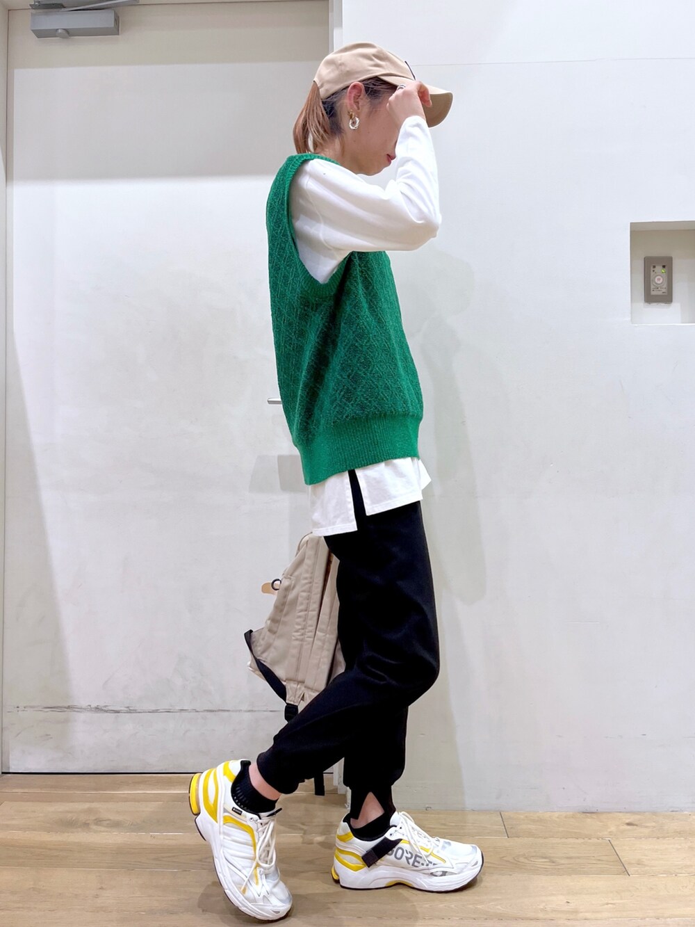 グリーン系のベスト、ホワイト系のTシャツ/カットソー、ベージュ系のバックパック/リュックを着用したレディースの冬コーディネートの6枚目の写真