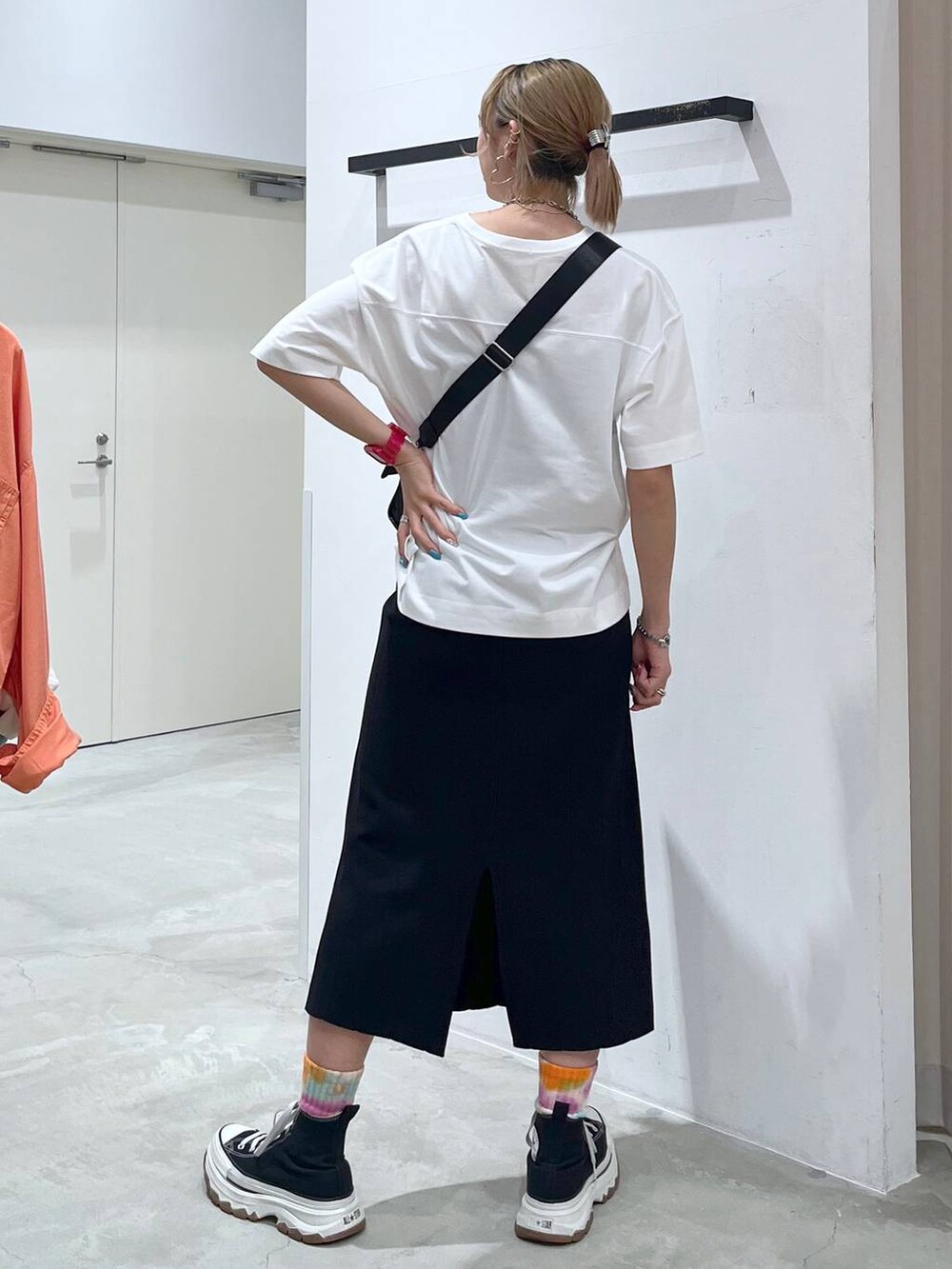 ブラック系のショルダーバッグ、ピンク系のTシャツ/カットソー、ブラック系のスカートを着用したレディースの夏コーディネートの5枚目の写真