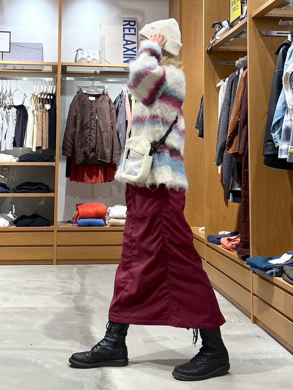 レッド系のスカート、ホワイト系のショルダーバッグ、ホワイト系のニット/セーターを着用したレディースの冬コーディネートの4枚目の写真