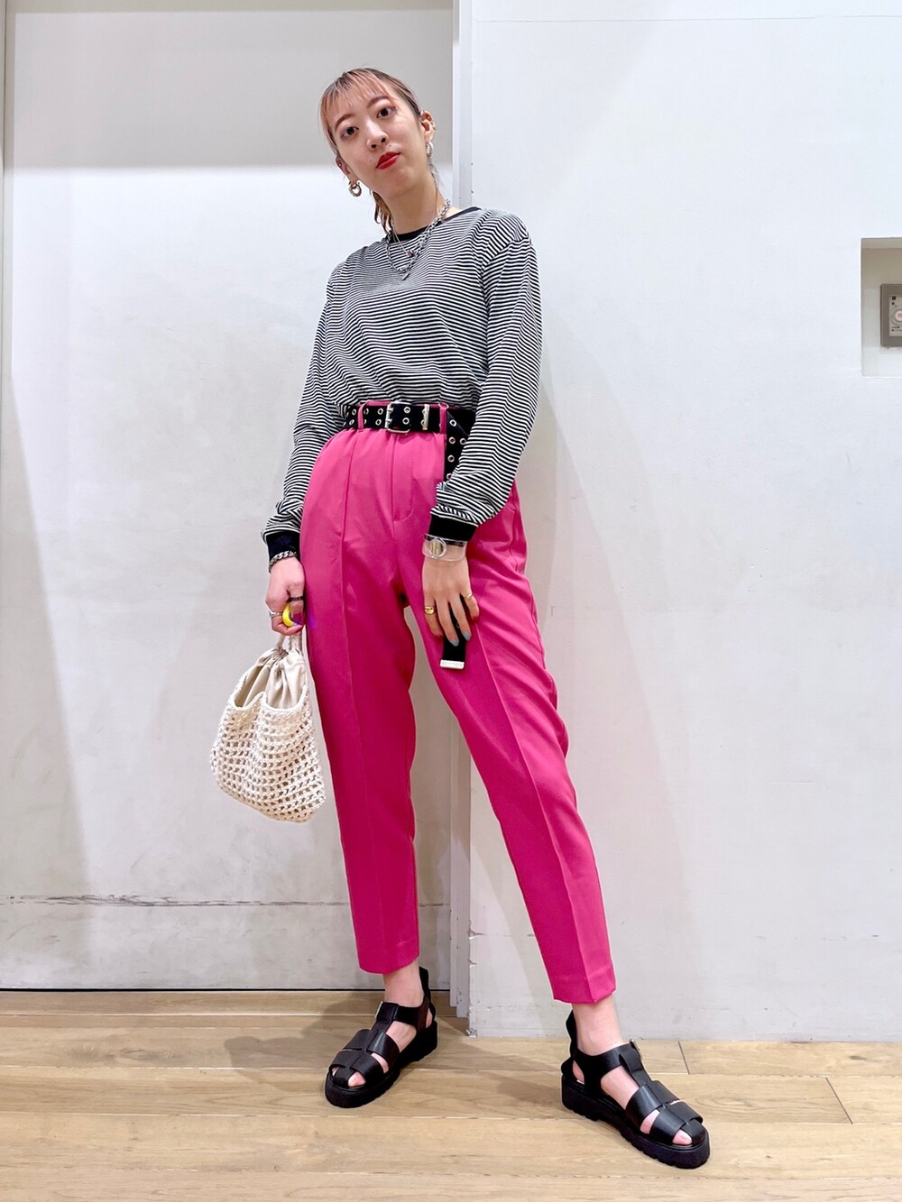 ブラック系のTシャツ/カットソー、イエロー系のその他パンツ、ベージュ系のバッグを着用したレディースの冬コーディネートの2枚目の写真