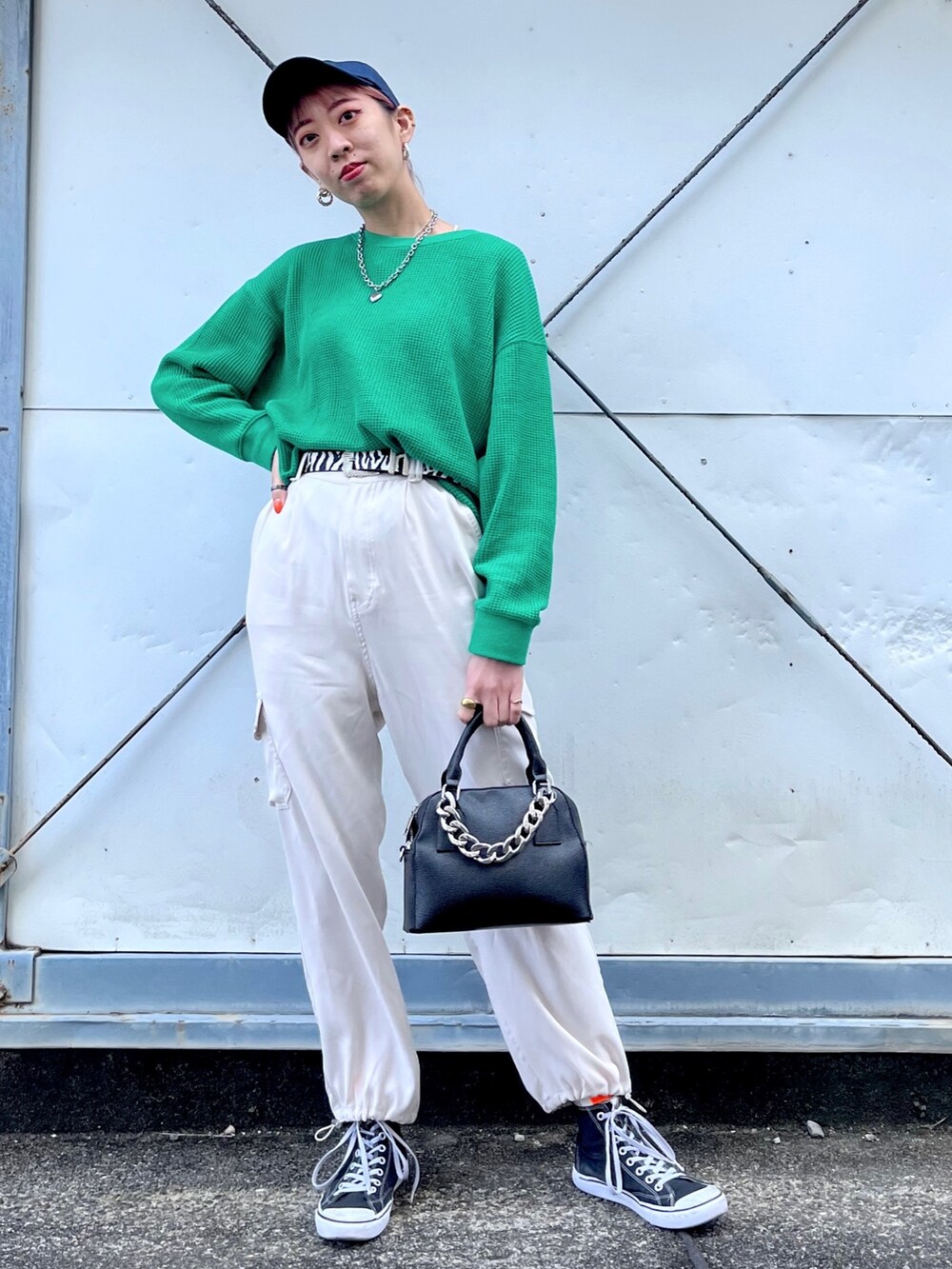 グリーン系のTシャツ/カットソー、ホワイト系のパンツ、ブラック系のショルダーバッグを着用したレディースの冬コーディネートの2枚目の写真