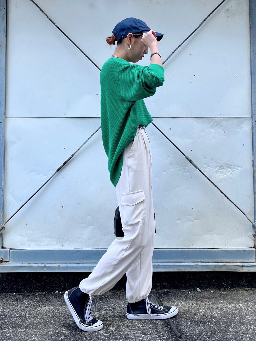 グリーン系のTシャツ/カットソー、ホワイト系のパンツ、ブラック系のショルダーバッグを着用したレディースの冬コーディネートの3枚目の写真
