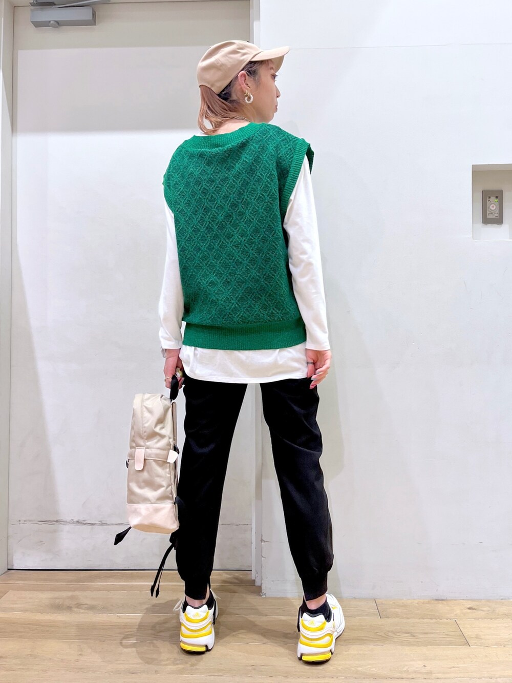 グリーン系のベスト、ホワイト系のTシャツ/カットソー、ベージュ系のバックパック/リュックを着用したレディースの冬コーディネートの5枚目の写真