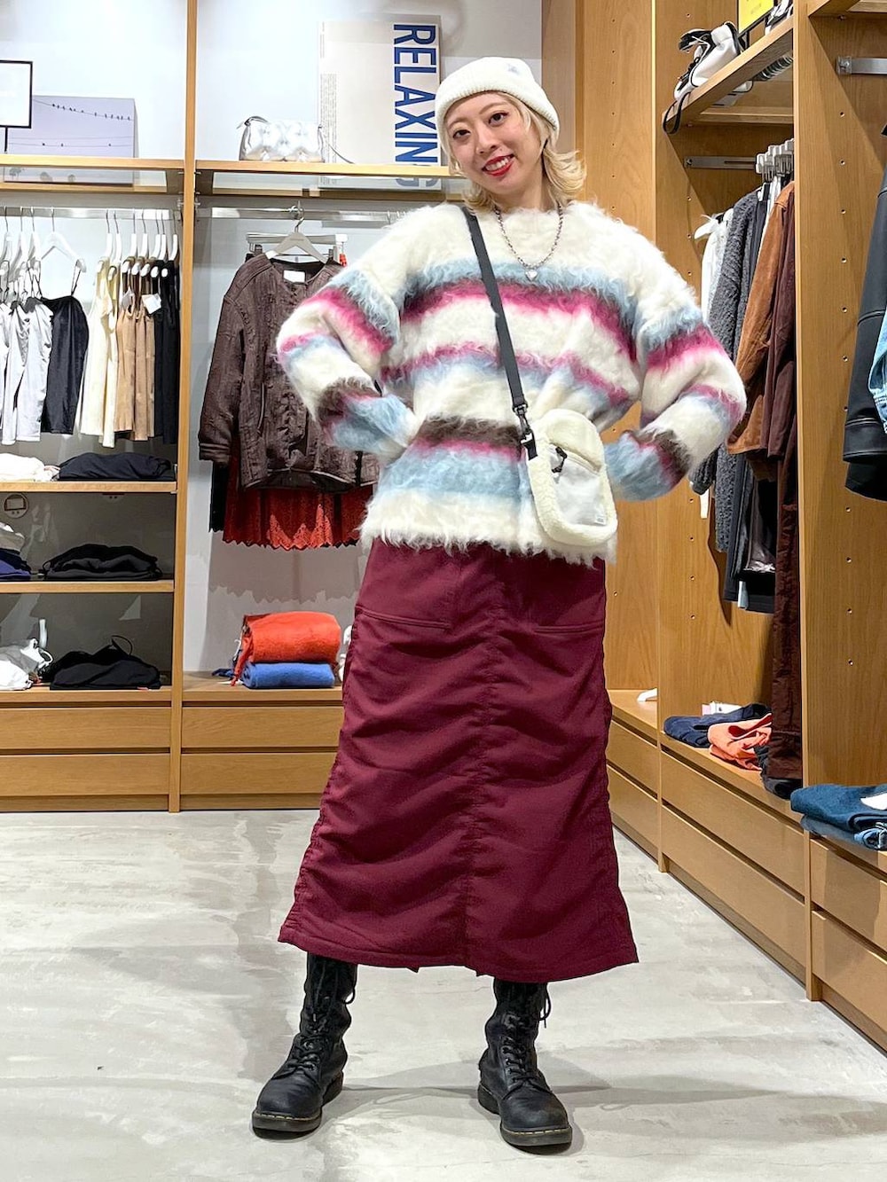 レッド系のスカート、ホワイト系のショルダーバッグ、ホワイト系のニット/セーターを着用したレディースの冬コーディネートの2枚目の写真