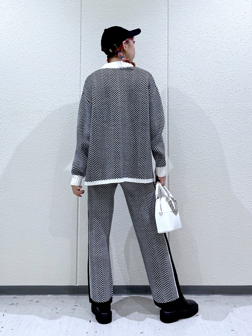 ブラック系のニット/セーター、ホワイト系のショルダーバッグ、ブラック系のその他パンツを着用したレディースの冬コーディネートの5枚目の写真
