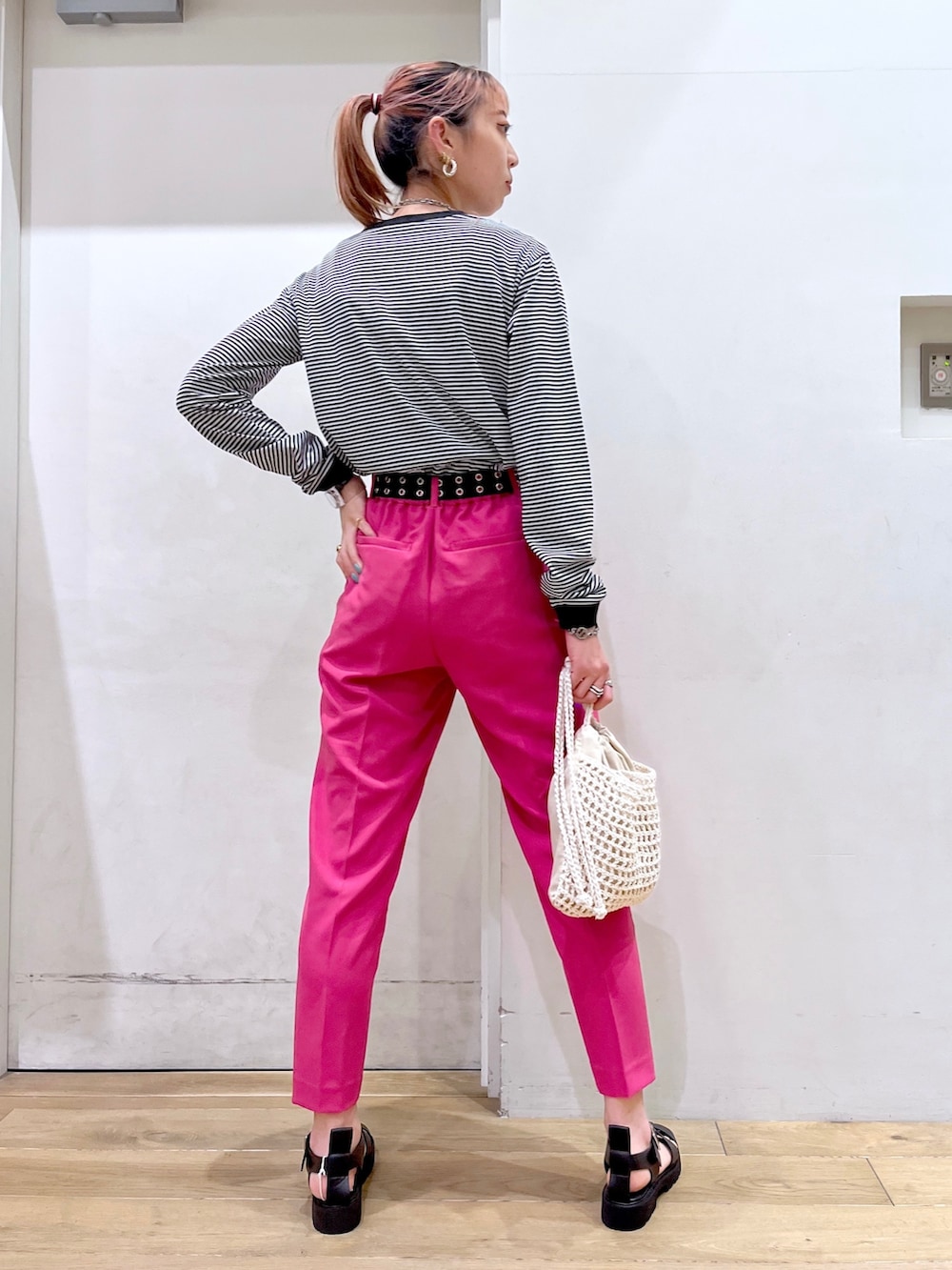 ブラック系のTシャツ/カットソー、イエロー系のその他パンツ、ベージュ系のバッグを着用したレディースの冬コーディネートの4枚目の写真