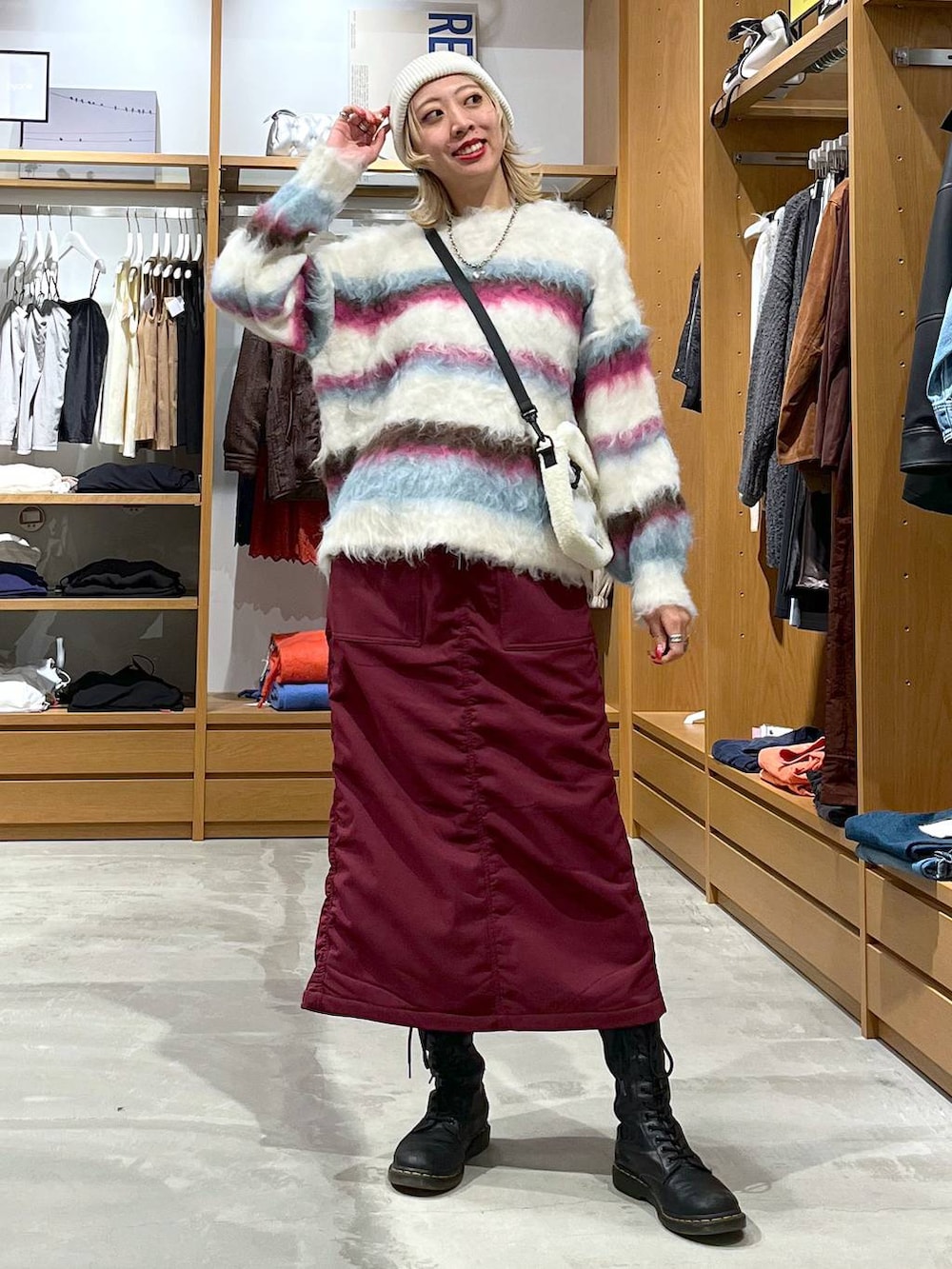 レッド系のスカート、ホワイト系のショルダーバッグ、ホワイト系のニット/セーターを着用したレディースの冬コーディネートの8枚目の写真