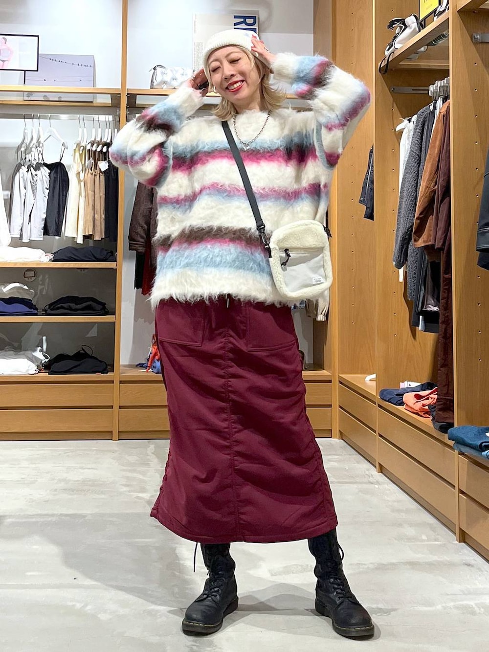 レッド系のスカート、ホワイト系のショルダーバッグ、ホワイト系のニット/セーターを着用したレディースの冬コーディネートの3枚目の写真