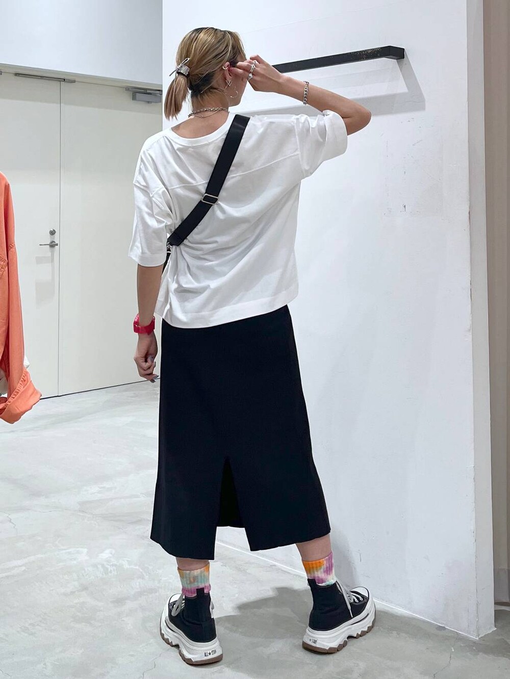 ブラック系のショルダーバッグ、ピンク系のTシャツ/カットソー、ブラック系のスカートを着用したレディースの夏コーディネートの6枚目の写真