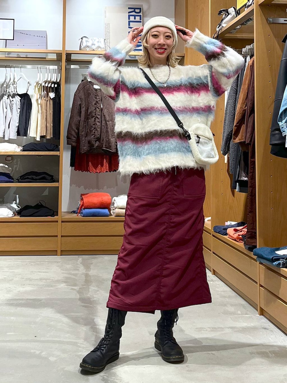 レッド系のスカート、ホワイト系のショルダーバッグ、ホワイト系のニット/セーターを着用したレディースの冬コーディネートの9枚目の写真