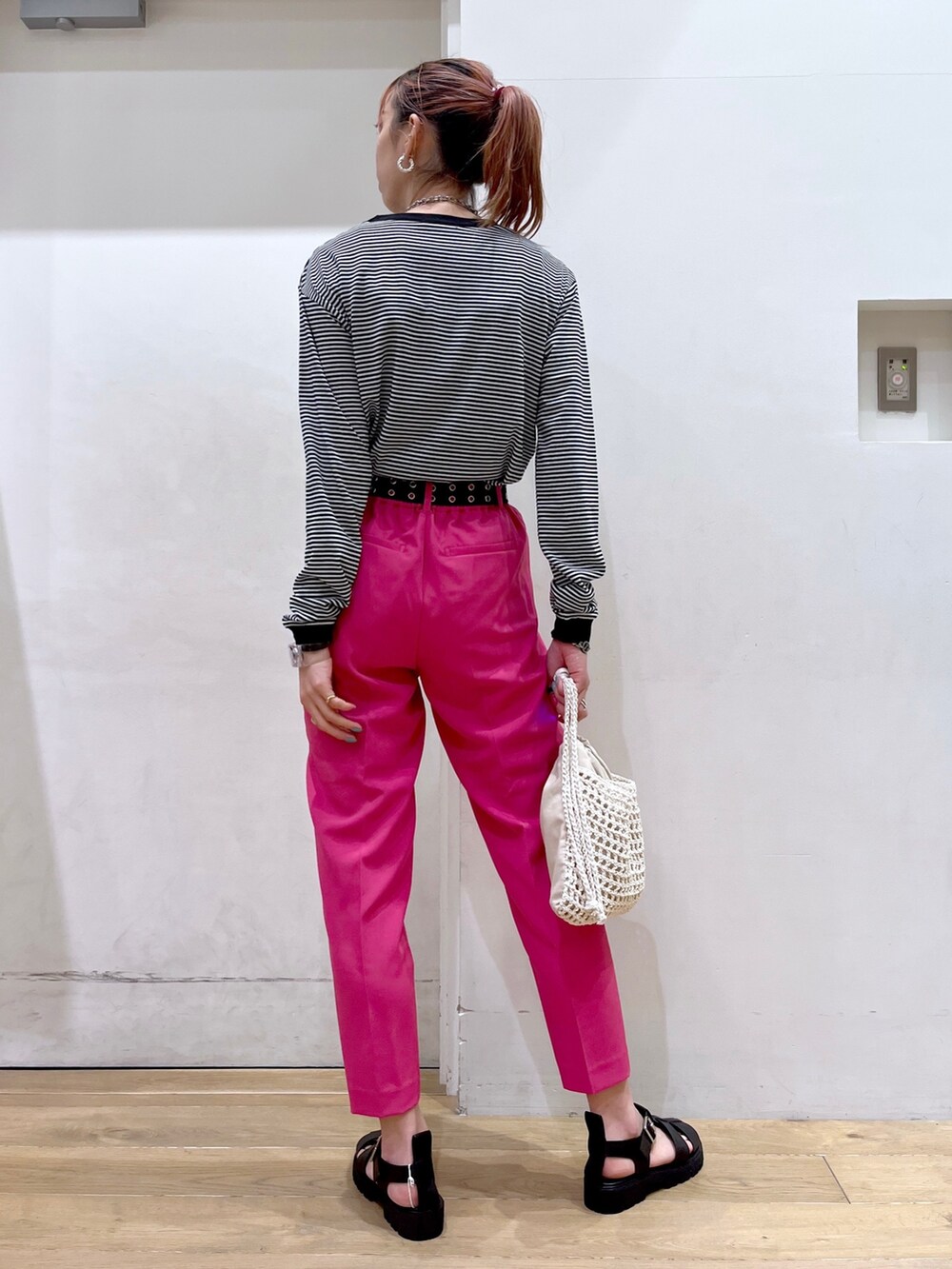 ブラック系のTシャツ/カットソー、イエロー系のその他パンツ、ベージュ系のバッグを着用したレディースの冬コーディネートの5枚目の写真