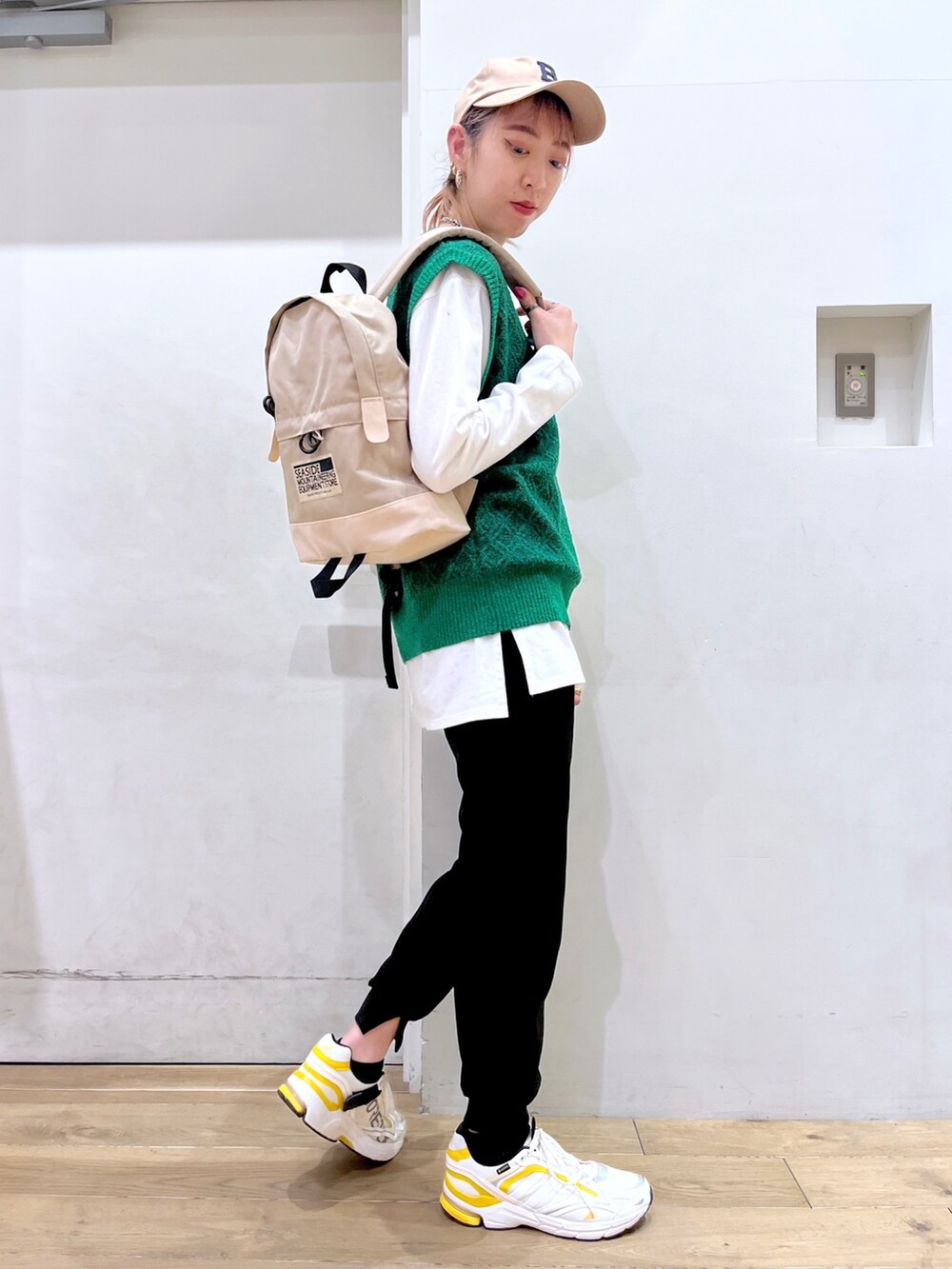 グリーン系のベスト、ホワイト系のTシャツ/カットソー、ベージュ系のバックパック/リュックを着用したレディースの冬コーディネートの7枚目の写真