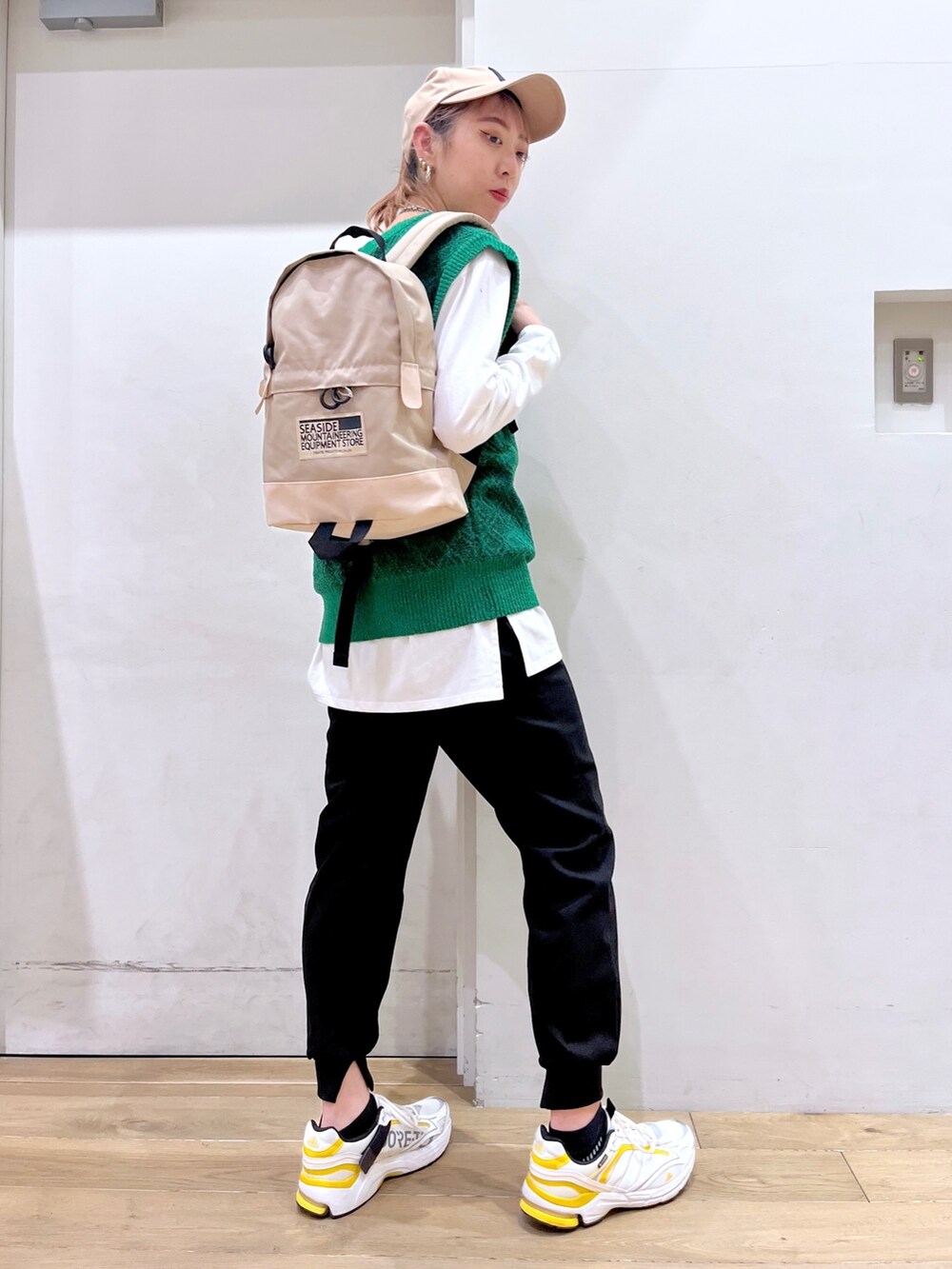 グリーン系のベスト、ホワイト系のTシャツ/カットソー、ベージュ系のバックパック/リュックを着用したレディースの冬コーディネートの8枚目の写真