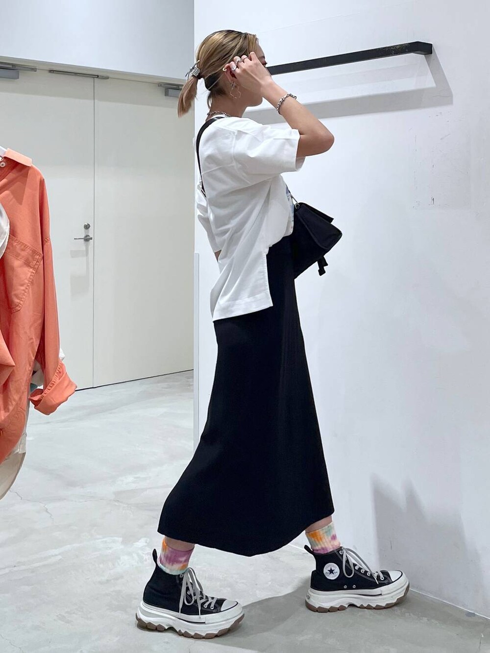 ブラック系のショルダーバッグ、ピンク系のTシャツ/カットソー、ブラック系のスカートを着用したレディースの夏コーディネートの7枚目の写真