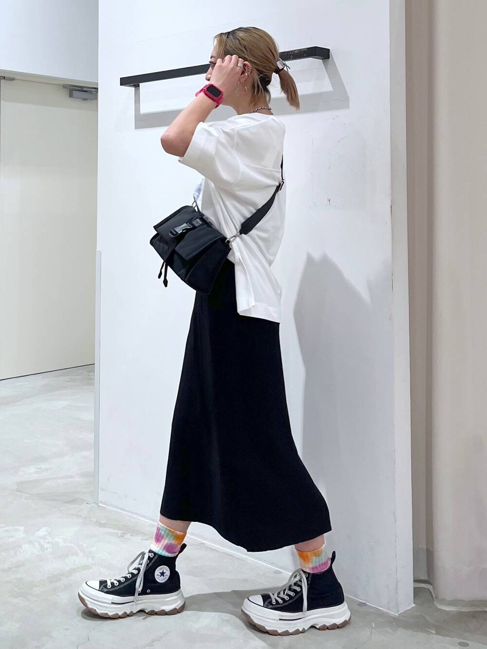 ブラック系のショルダーバッグ、ピンク系のTシャツ/カットソー、ブラック系のスカートを着用したレディースの夏コーディネートの4枚目の写真