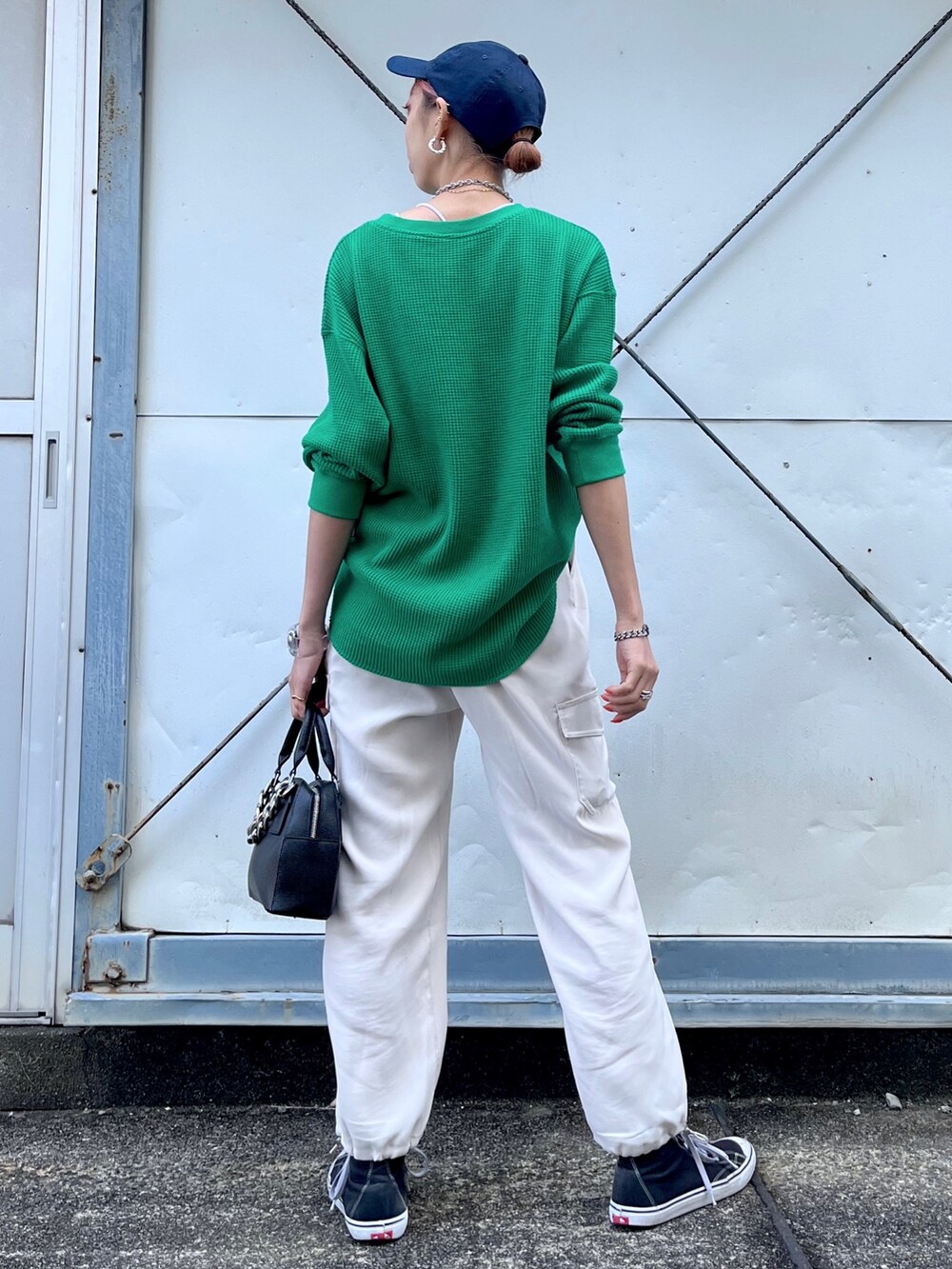 グリーン系のTシャツ/カットソー、ホワイト系のパンツ、ブラック系のショルダーバッグを着用したレディースの冬コーディネートの5枚目の写真