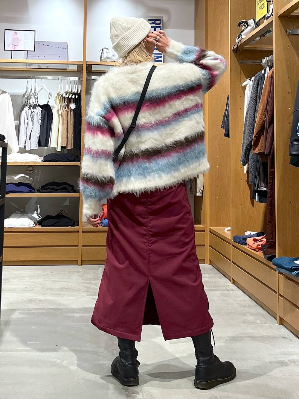 レッド系のスカート、ホワイト系のショルダーバッグ、ホワイト系のニット/セーターを着用したレディースの冬コーディネートの6枚目の写真