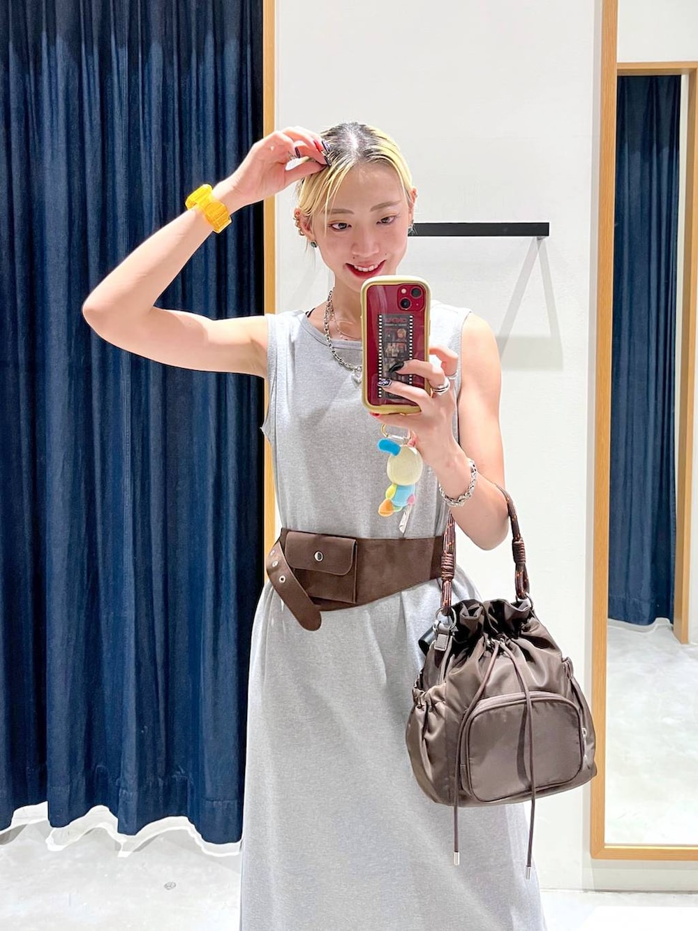 グレー系のワンピース、ブラウン系のショルダーバッグを着用したレディースの夏コーディネートの4枚目の写真