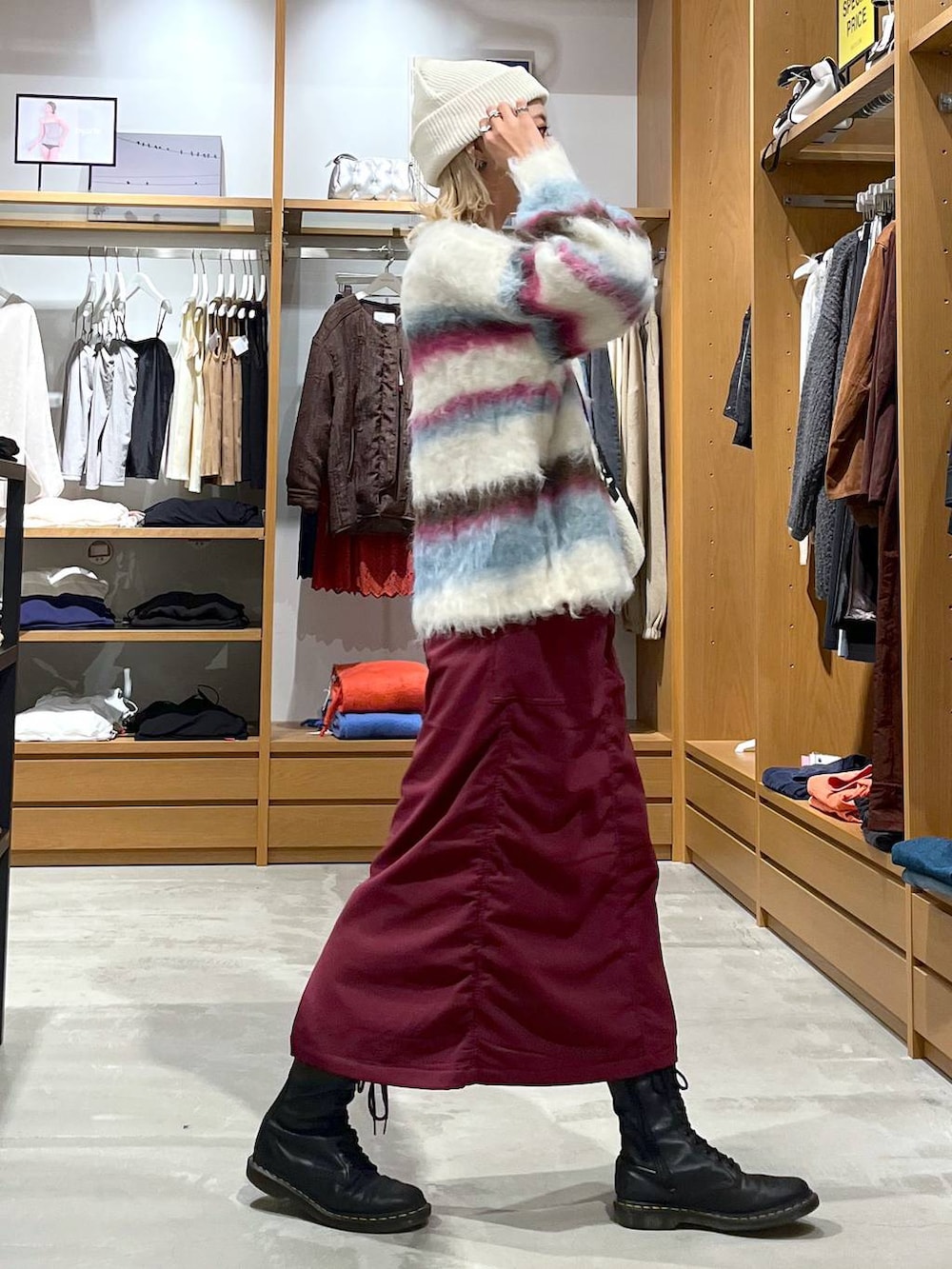 レッド系のスカート、ホワイト系のショルダーバッグ、ホワイト系のニット/セーターを着用したレディースの冬コーディネートの7枚目の写真