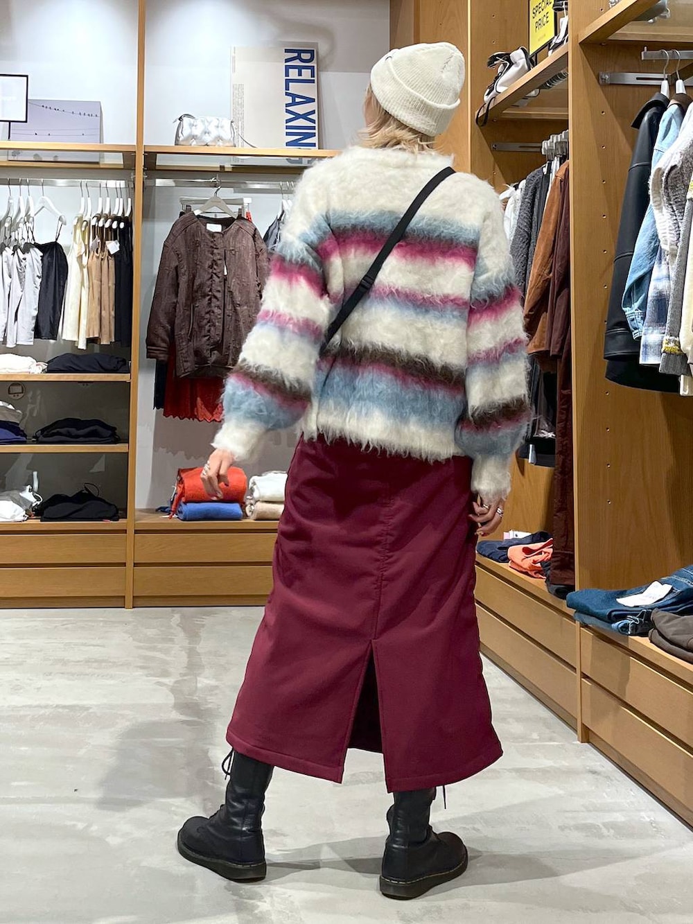 レッド系のスカート、ホワイト系のショルダーバッグ、ホワイト系のニット/セーターを着用したレディースの冬コーディネートの5枚目の写真