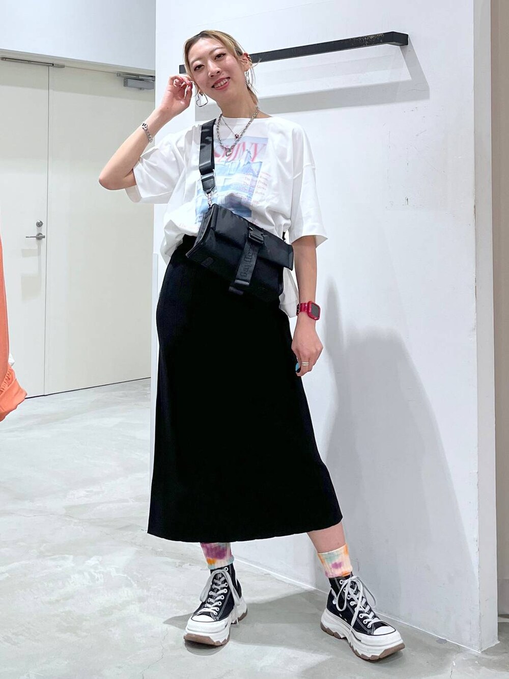 ブラック系のショルダーバッグ、ピンク系のTシャツ/カットソー、ブラック系のスカートを着用したレディースの夏コーディネートの8枚目の写真