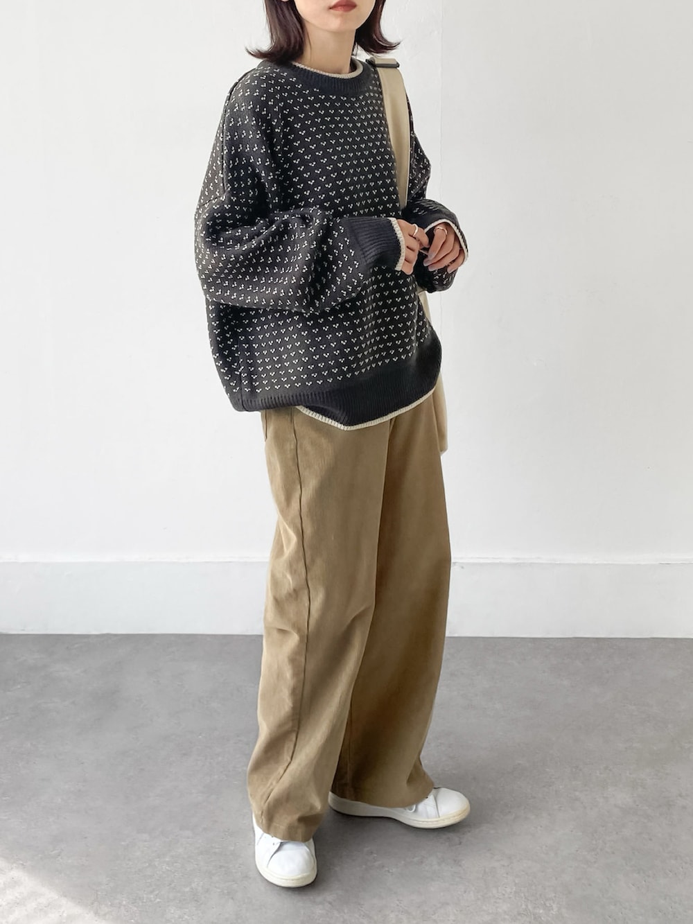 グレー系のニット/セーター、ベージュ系のその他パンツを着用したレディースの冬コーディネートの2枚目の写真