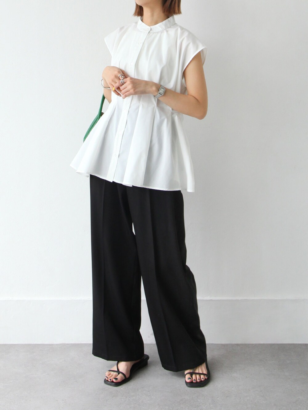 ブラック系のスラックス、ホワイト系のシャツ/ブラウスを着用したレディースの夏コーディネートの2枚目の写真
