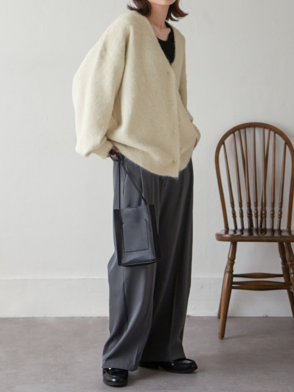 ホワイト系のカーディガン/ボレロ、グレー系のスラックスを着用したレディースの秋コーディネートの3枚目の写真