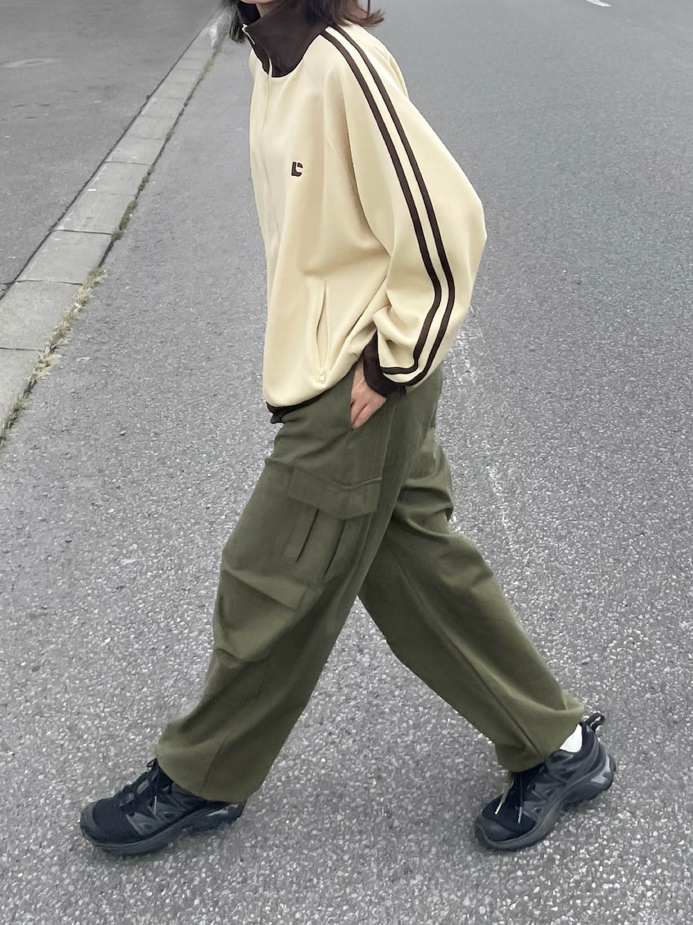 ベージュ系のブルゾン、グリーン系のカーゴパンツを着用したレディースの春コーディネートの2枚目の写真