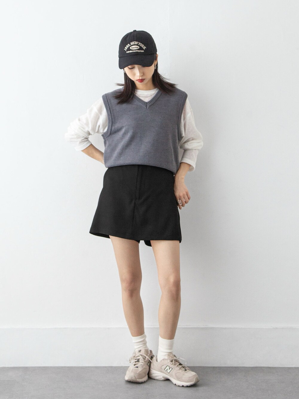 ホワイト系のTシャツ/カットソー、グレー系のベスト、ブラック系のスカートを着用したレディースの冬コーディネートの2枚目の写真