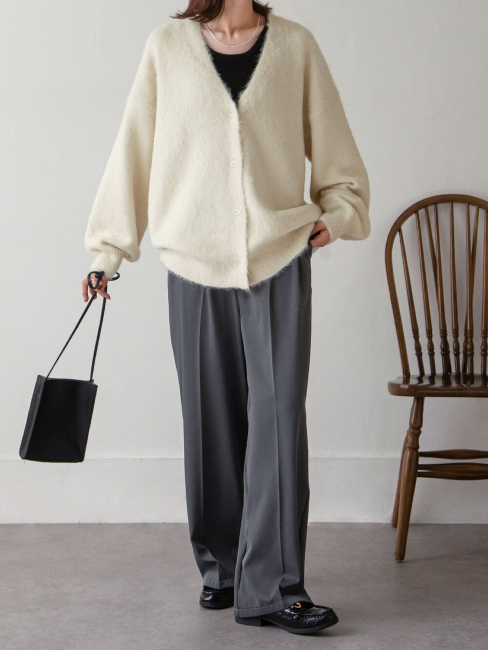 ホワイト系のカーディガン/ボレロ、グレー系のスラックスを着用したレディースの秋コーディネートの2枚目の写真