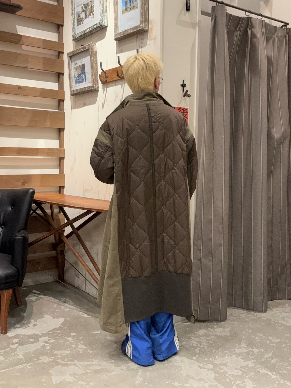 グリーン系のモッズコート、グレー系のニット/セーター、ブルー系のスウェットパンツを着用したメンズの冬コーディネートの3枚目の写真